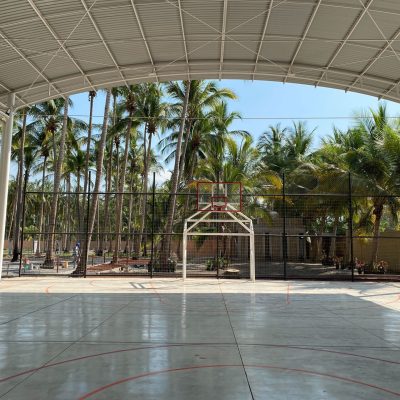 Covered basketball court surrounded by palm trees, part of a community complex in Mexico built with the Fairtrade premium.